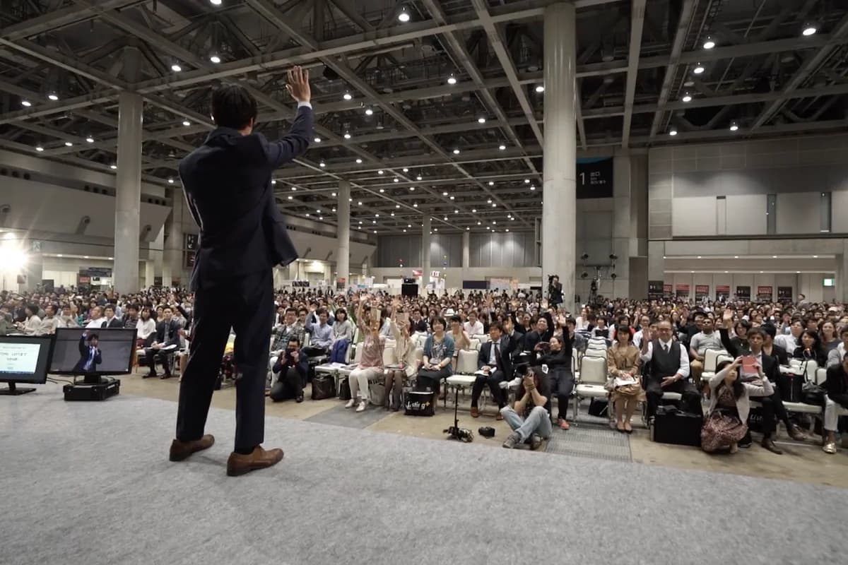 講演の様子 - 大勢の聴衆を前に登壇する奥津周朔